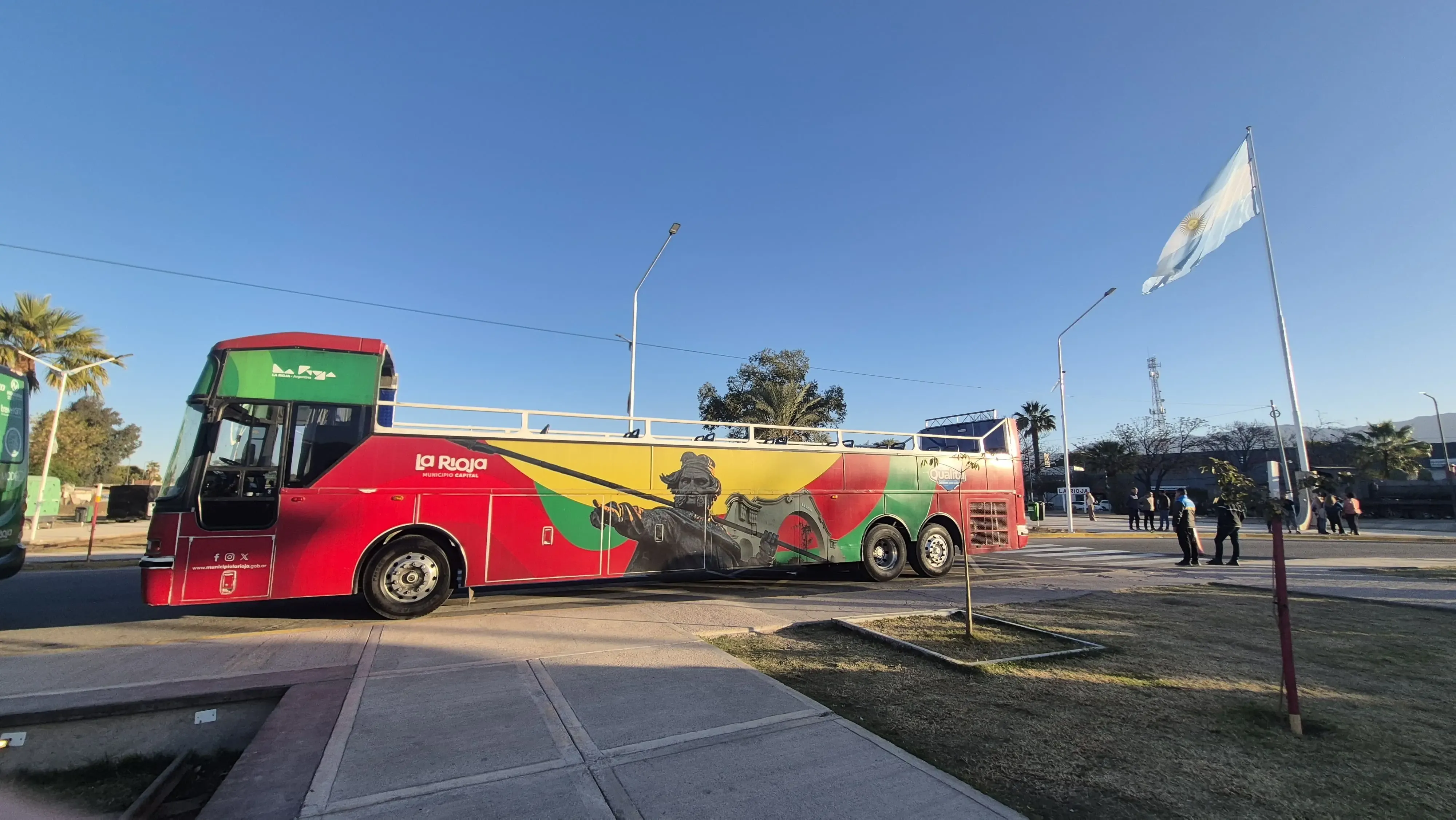 Bus Turístico con bandera argentina de fondo - Sulpayki Viajes y turismo